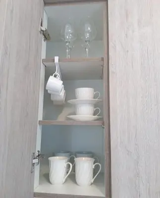 a cupboard with cups and plates and wine glasses at Akrivis studio in Athens
