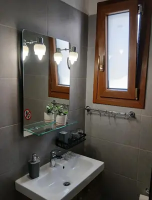 a bathroom with a sink and a mirror at Akrivis studio in Athens