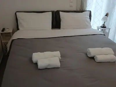 two towels on a bed with two pillows on it at Akrivis studio in Athens