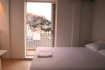 a bedroom with a bed and a large window at A room with a view in Athens