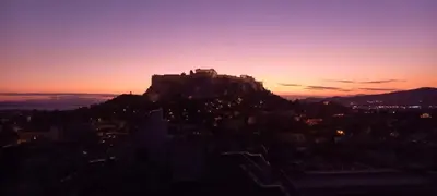 a building on top of a mountain at sunset at A room with a view in Athens