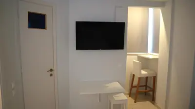 a white room with a television on a wall at A room with a view in Athens