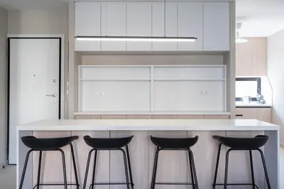 a kitchen with a white counter with three bar stools at LIV - Deluxe 2BD Apartment in Athens in Athens