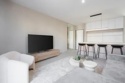 a living room with a television and a table with stools at LIV - Deluxe 2BD Apartment in Athens in Athens