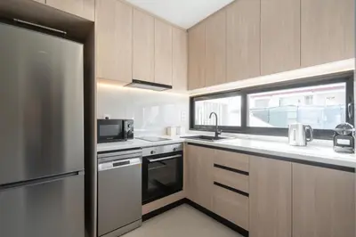 a kitchen with stainless steel appliances and a window at LIV - Deluxe 2BD Apartment in Athens in Athens
