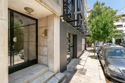 a building on a street with a car parked on the sidewalk at Chilli & Chill in Athens