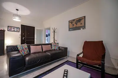 a living room with a leather couch and a chair at Chic 2-Bdrm Oasis in Pangrati by ΜΡS in Athens