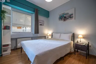 a bedroom with a large bed and a window at Chic 2-Bdrm Oasis in Pangrati by ΜΡS in Athens