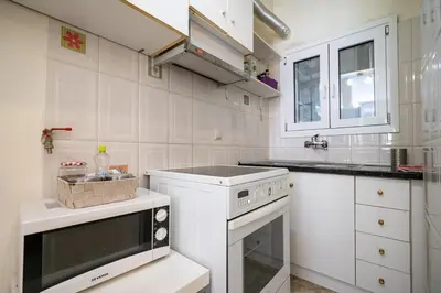 a white kitchen with a stove and a sink at Chic 2-Bdrm Oasis in Pangrati by ΜΡS in Athens