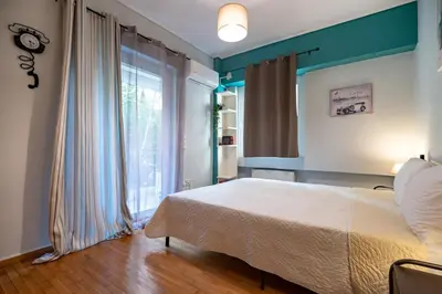 a bedroom with a bed and a large window at Chic 2-Bdrm Oasis in Pangrati by ΜΡS in Athens