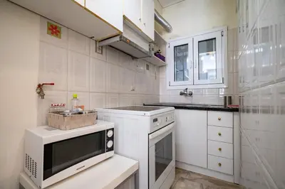 a white kitchen with a sink and a microwave at Chic 2-Bdrm Oasis in Pangrati by ΜΡS in Athens