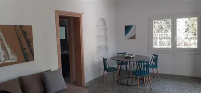 a room with a table and chairs and a window at Archontiko Voulas D in Athens