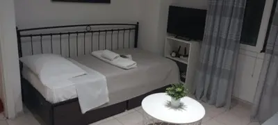 a bedroom with a bed with a table and a tv at Sweet Nest in Piraeus