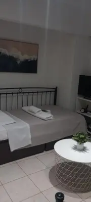 a bedroom with a bed and a table with a plant at Sweet Nest in Piraeus