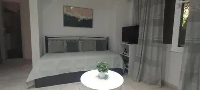 a bedroom with a bed and a table with a plant on it at Sweet Nest in Piraeus