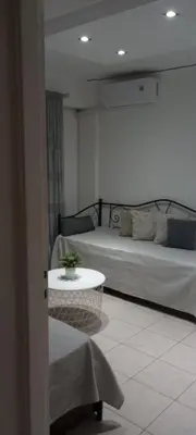 a room with two beds and a table in a room at Sweet Nest in Piraeus