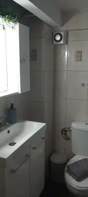 a bathroom with a sink and a toilet and a window at Sweet Nest in Piraeus
