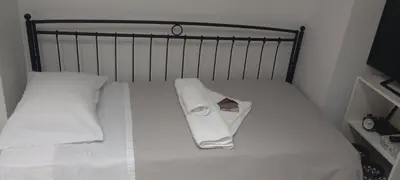 a bed with white sheets and a towel on it at Sweet Nest in Piraeus