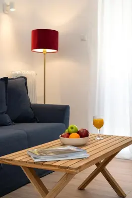 a wooden coffee table with a bowl of fruit and a glass of juice at Encrin Apartment by LobbySquare in Athens