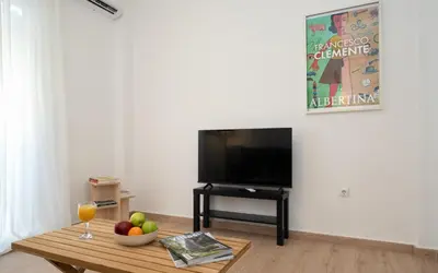 a living room with a television and a table with a bowl of fruit at Encrin Apartment by LobbySquare in Athens