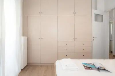 a bedroom with white cabinets and a bed at Encrin Apartment by LobbySquare in Athens