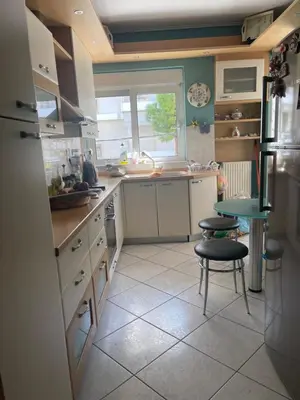 a kitchen with a sink and a table and a chair at Cozy apartment Neo Psychiko in Athens