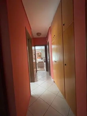 a hallway of a house with orange walls and a floor at Cozy apartment Neo Psychiko in Athens