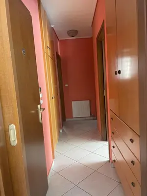 a hallway with orange walls and an open door at Cozy apartment Neo Psychiko in Athens
