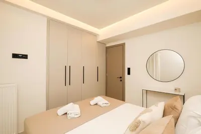 a bedroom with a large bed and a mirror at Sunny Seaside Cozy Home in Piraeus