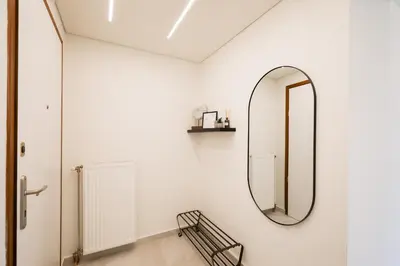 a mirror on the wall in a white room at Sunny Seaside Cozy Home in Piraeus