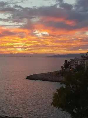 a sunset over a large body of water at Sunny Seaside Cozy Home in Piraeus