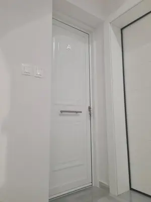 a white door in a white room with a mirror at IVory Suites near Athens Airport in Spáta