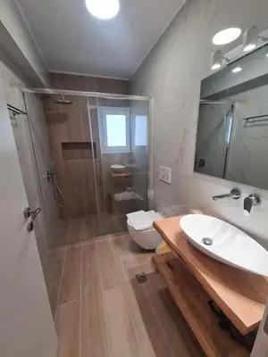 a bathroom with a shower and a sink and a toilet at IVory Suites near Athens Airport in Spáta