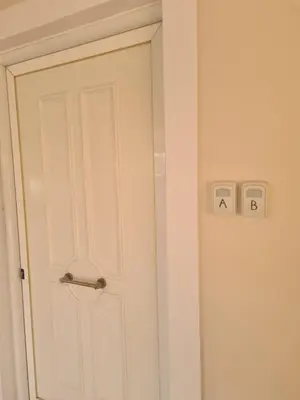 a white door with two switches on the wall at IVory Suites near Athens Airport in Spáta