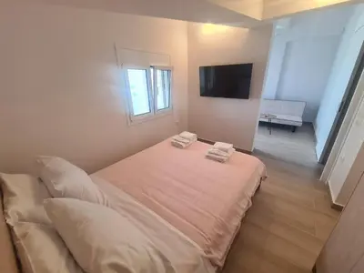 a bedroom with a bed with two towels on it at IVory Suites near Athens Airport in Spáta