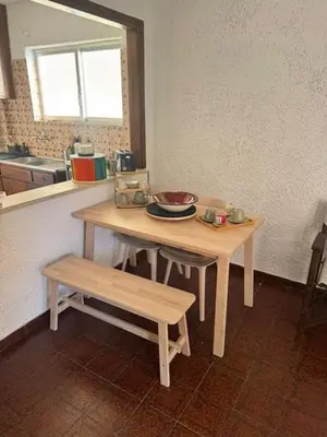 a table and bench in a kitchen with a sink at Aggelakos Rooms in Porto Rafti
