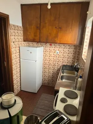 a kitchen with a white refrigerator and a sink at Aggelakos Rooms in Porto Rafti