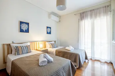 a bedroom with two beds with towels on them at Beach & City - Glyfada 2BR in Athens