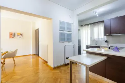 a kitchen with a table and a dining room at Beach & City - Glyfada 2BR in Athens