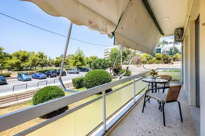 a balcony with a table and chairs and a street at Beach & City - Glyfada 2BR in Athens
