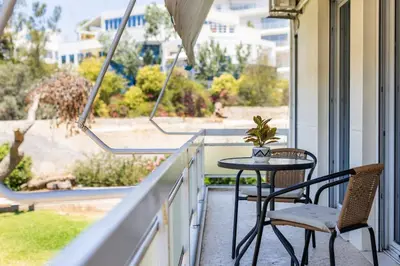 a balcony with a table and two chairs and a window at Beach & City - Glyfada 2BR in Athens