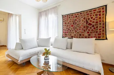 a living room with a white couch and a glass table at Beach & City - Glyfada 2BR in Athens