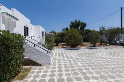 a stone walkway in front of a white building at Villa Svoronou Athens Riviera in Áyios Nikólaos