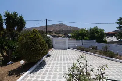 a garden with a stone walkway and a fence at Villa Svoronou Athens Riviera in Áyios Nikólaos