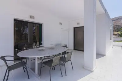 a patio with a table and chairs on a balcony at Villa Svoronou Athens Riviera in Áyios Nikólaos
