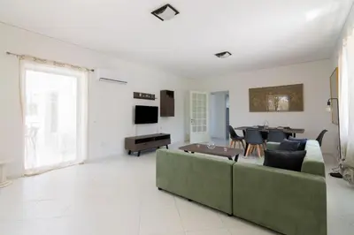 a living room with a couch and a table at Villa Svoronou Athens Riviera in Áyios Nikólaos