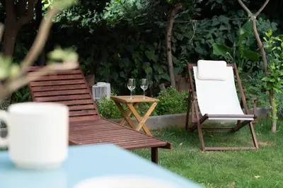 two chairs and a table and two glasses of wine at Garden Level Gem in the City in Athens