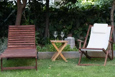 two chairs and a table with two glasses of wine at Garden Level Gem in the City in Athens