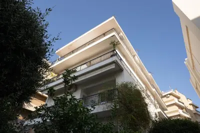 a white building with a balcony on the side of it at Garden Level Gem in the City in Athens