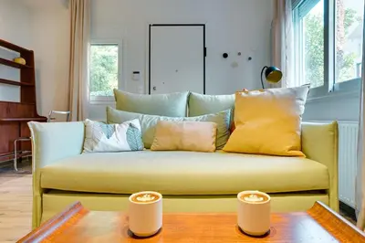 a yellow couch in a living room with a table at Garden Level Gem in the City in Athens